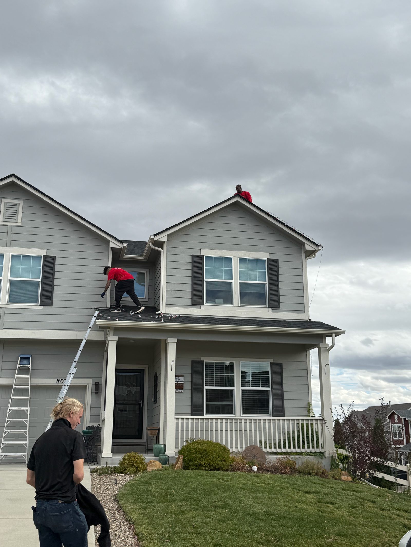 Our Front Range crew installing warm white C9 Christmas lights on a two-story home roofline